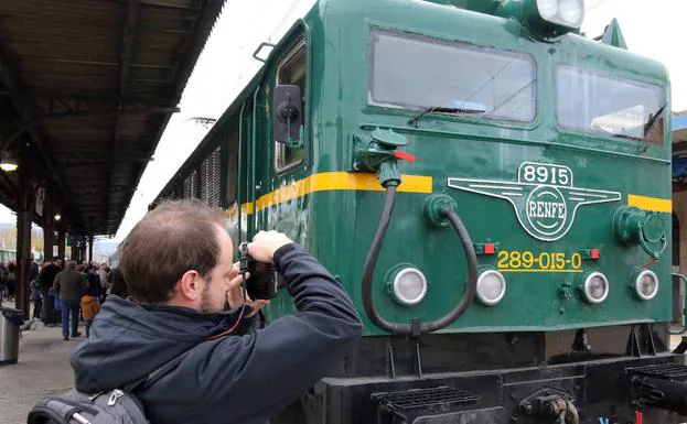 Un hombre fotografía la locomotora del tren histórico de los 130 años de la línea Villalba-Segovia, este sábado. 