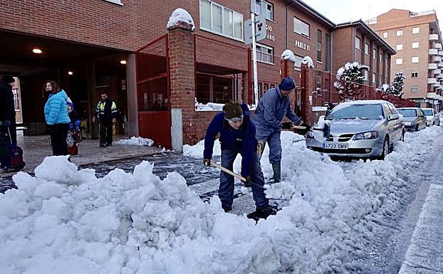 Vecinos retiran nieve de la calzada en Ávila en enero de 2018. 