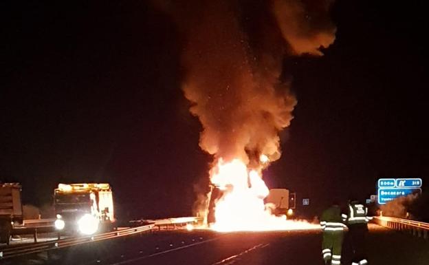 Imagen del camión ardiendo en medio de la calzada.