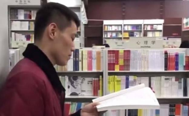 El joven espera en la librería a la chica de la que se enamoró.