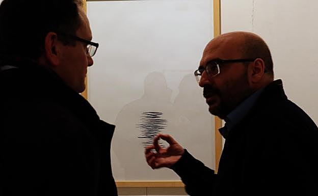 Rafael Vega, a la derecha, habla con uno de los asistentes a su exposición. 