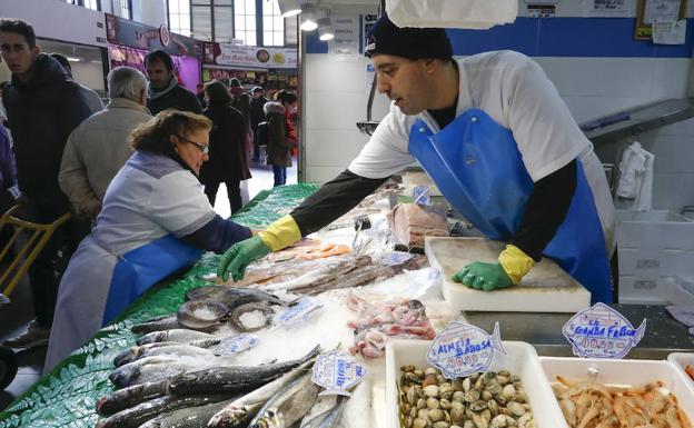 Un pescadero coloca el género de su mostrador. 