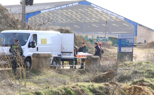 Agentes de la Guardia Civil y del serivicio forense introducen el cadáver del desaparecido en una furgoneta..