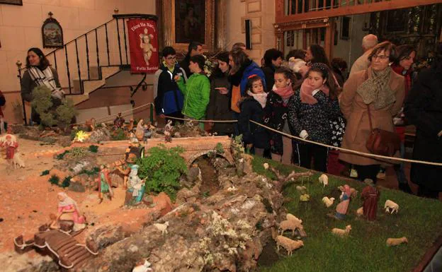 Un grupo de personas observa el belén expuesto en la ermita del Cristo del Mercado.