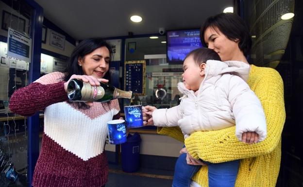 Yolanda Herrero (I) celebra con su familia el haber repartido parte del segundo premio de la Loteria del Niño en su administración de Miranda de Ebro. 