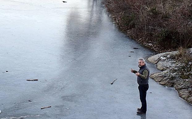 Un hombre pisa el Pontón Alto de Segovia congelado, este lunes por la tarde. 