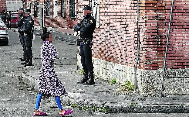 Una vecina pasa entre tres agentes de la UIP, este miércoles en Las Viudas. 