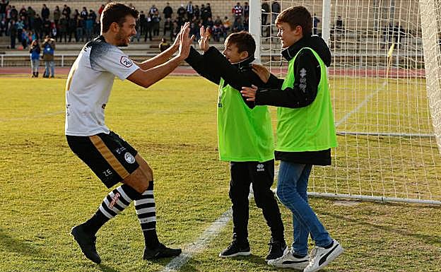 Carlos de la Nava celebra con dos jóvenes canteranos un gol en Las Pistas. 
