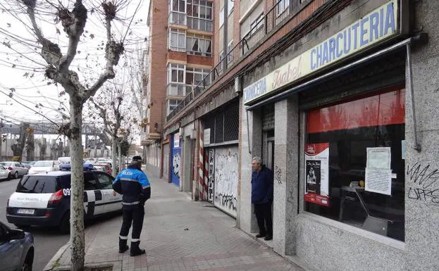 Un policía local charla con el carnicero de la avenida de Irún que sufrió el intento de robo el martes. 