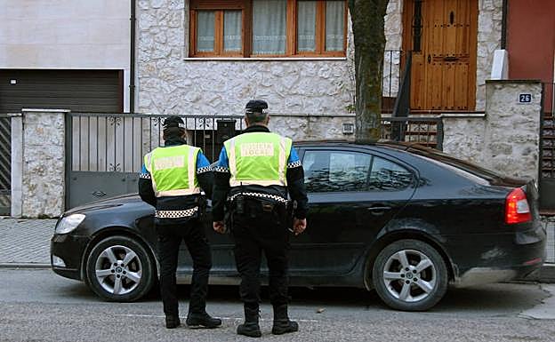 Dos agentes de la Policía Local, junto a un vehículo. 