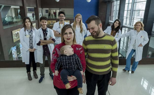 Susana Lobato y Javier de la Iglesia posan con su pequeño Marcos. Detrás, Andrea Díaz (estudiante de Medicina); Rodrigo Nájera y Esteban Fuentes (MIR de Digestivo); Laura Hernández (MIR de Medicina Interna); Carolina Almohalla, médico adjunto de la Unidad de Hepatología y Gloria Sánchez Antolín, jefe de Digestivo, en el Río Hortega.