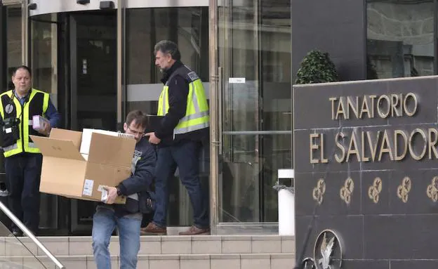 Los agentes sacan cajas con documentos del tanatorio.