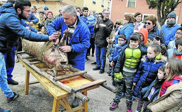 Mayores y niños siguen el ritual de la matanza.