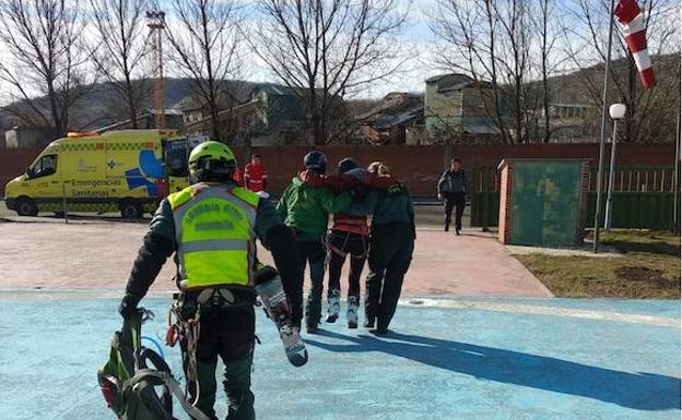 Los guardias civiles, con la esquiadora herida. 