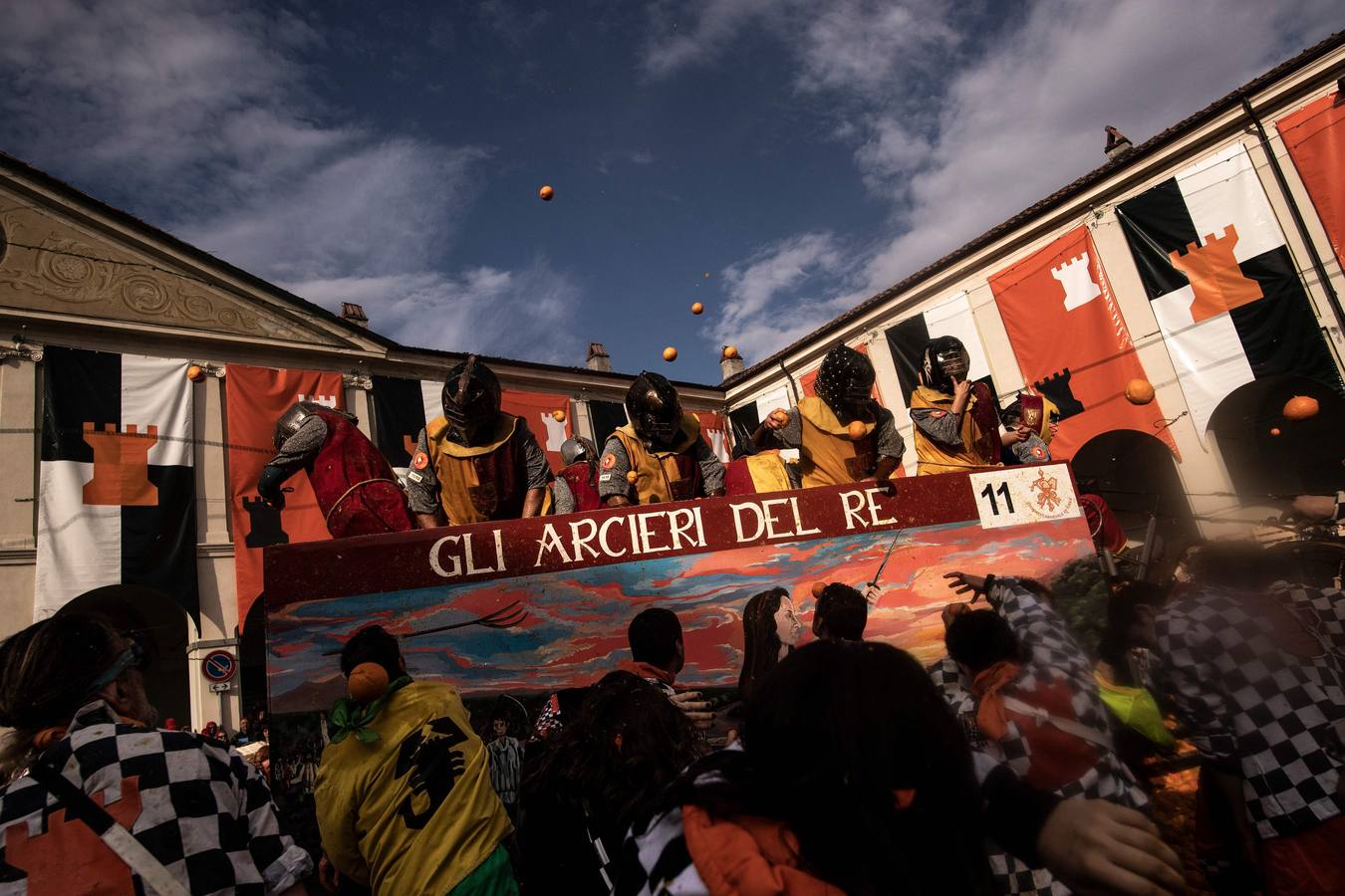 El histórico Carnaval de Ivrea, localidad de Piamonte en la provincia de Turín, representa la guerra civil entre el pueblo y las tropas reales napoleónicas, el día después de la muerte del odiado tirano Raineri de Bramante a manos de la 'Mugnaia' | Los equipos de lanzadores de naranjas a pie (el pueblo) defienden sus plazas de los lanzadores de los carros (el Estado Mayor Napoleónico) a golpe de naranja
