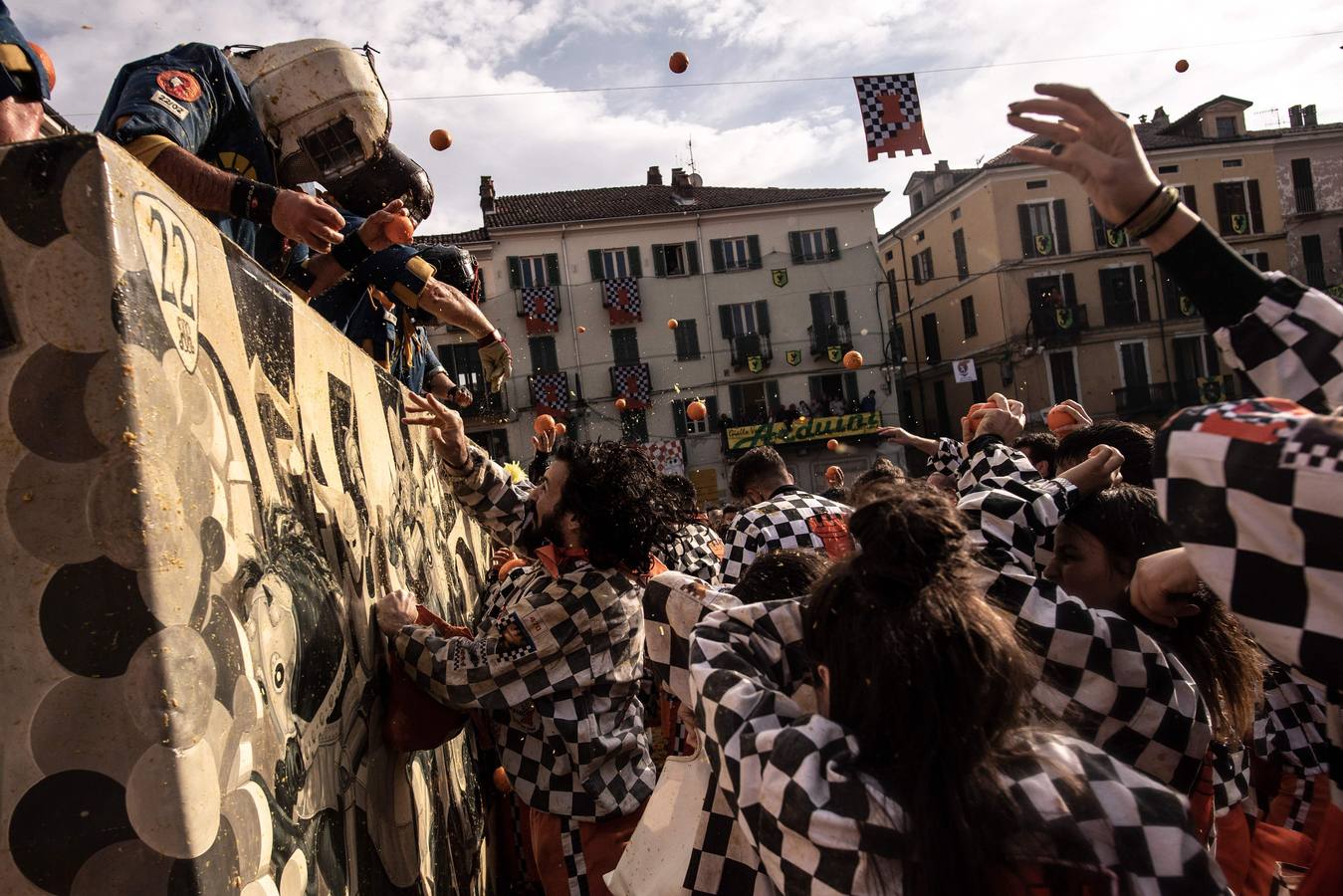 El histórico Carnaval de Ivrea, localidad de Piamonte en la provincia de Turín, representa la guerra civil entre el pueblo y las tropas reales napoleónicas, el día después de la muerte del odiado tirano Raineri de Bramante a manos de la 'Mugnaia' | Los equipos de lanzadores de naranjas a pie (el pueblo) defienden sus plazas de los lanzadores de los carros (el Estado Mayor Napoleónico) a golpe de naranja
