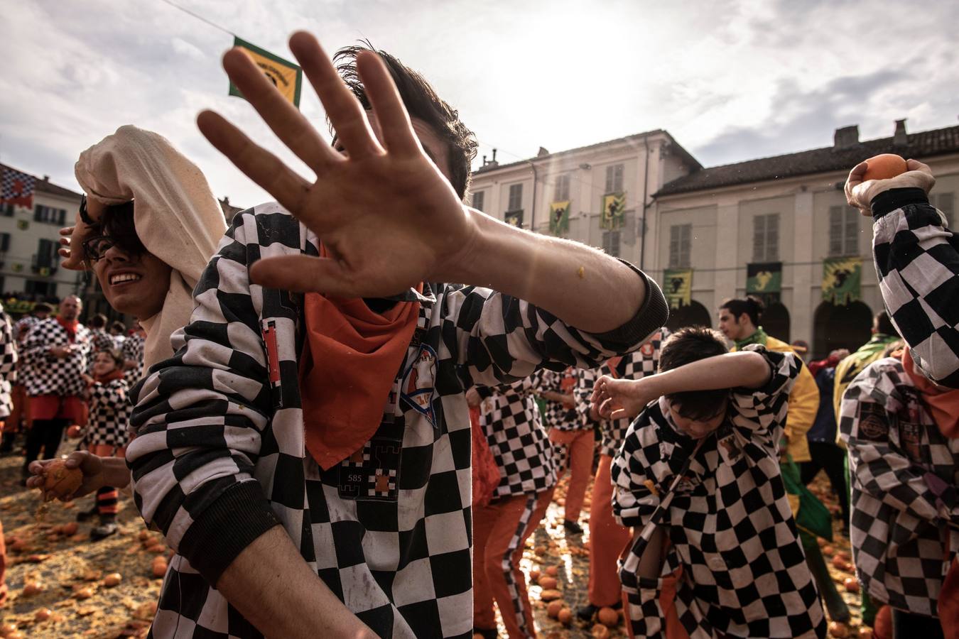 El histórico Carnaval de Ivrea, localidad de Piamonte en la provincia de Turín, representa la guerra civil entre el pueblo y las tropas reales napoleónicas, el día después de la muerte del odiado tirano Raineri de Bramante a manos de la 'Mugnaia' | Los equipos de lanzadores de naranjas a pie (el pueblo) defienden sus plazas de los lanzadores de los carros (el Estado Mayor Napoleónico) a golpe de naranja