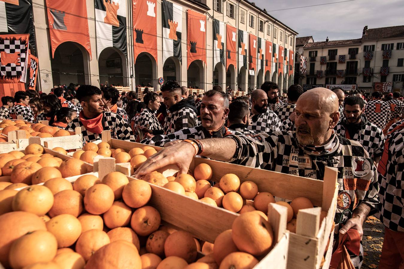 El histórico Carnaval de Ivrea, localidad de Piamonte en la provincia de Turín, representa la guerra civil entre el pueblo y las tropas reales napoleónicas, el día después de la muerte del odiado tirano Raineri de Bramante a manos de la 'Mugnaia' | Los equipos de lanzadores de naranjas a pie (el pueblo) defienden sus plazas de los lanzadores de los carros (el Estado Mayor Napoleónico) a golpe de naranja