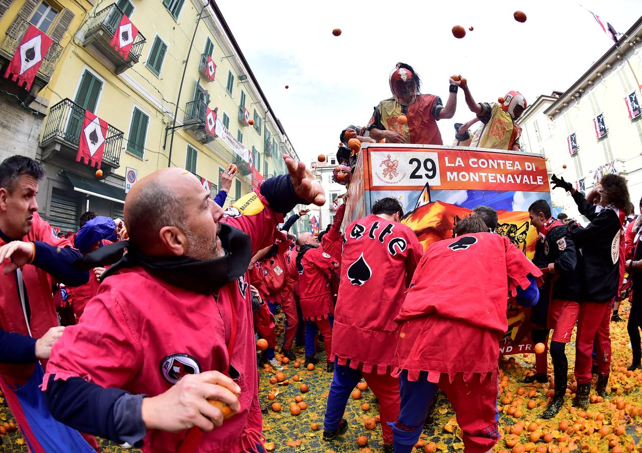 El histórico Carnaval de Ivrea, localidad de Piamonte en la provincia de Turín, representa la guerra civil entre el pueblo y las tropas reales napoleónicas, el día después de la muerte del odiado tirano Raineri de Bramante a manos de la 'Mugnaia' | Los equipos de lanzadores de naranjas a pie (el pueblo) defienden sus plazas de los lanzadores de los carros (el Estado Mayor Napoleónico) a golpe de naranja