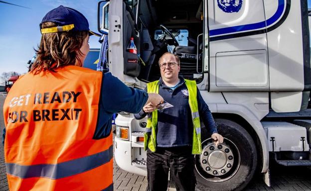 Una empleada del puerto de Róterdam entrega a un camionero información sobre el 'Brexit'.
