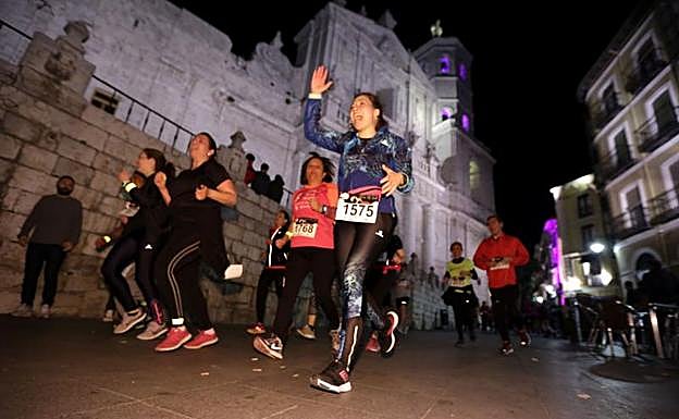 Los participantes en la carrera Ríos de Luz, ante la Catedral, iluminada a su paso.