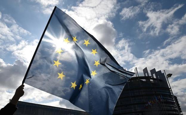 Un hombre ondea la bandera de la Unión Europea durante una manifestación en el exterior del Parlamento Europeo.