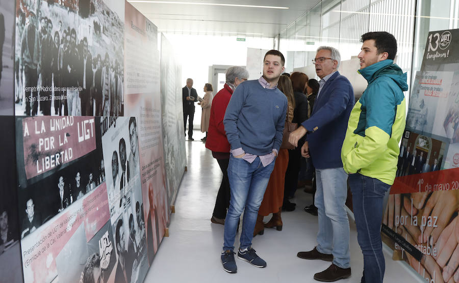 El subdelegado del Gobierno recorre la exposición con dos jóvenes.