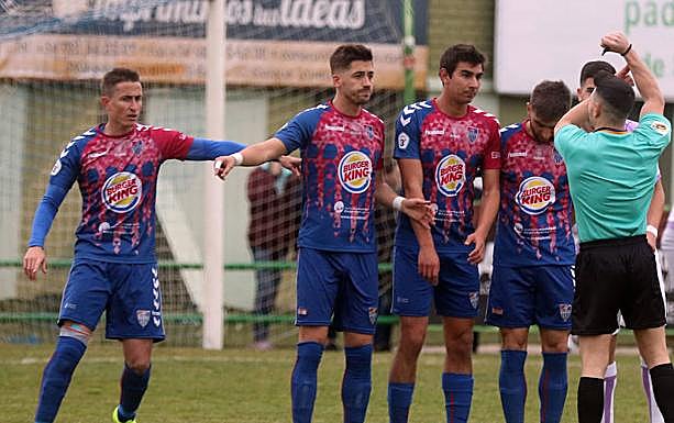 Jugadores de la Segoviana se preparan para formar una barrera ante las indicaciones del árbitro.