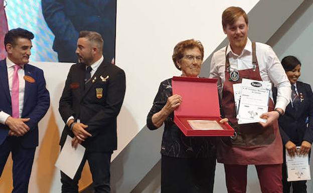 El barman Francisco Javier García Cantero recibió el primer premio de manos de Elidia de Paz, madre de los hermanos Panizo. 