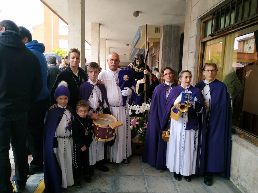 Cofrades de los nazarenos se resguardan de la lluvia. 