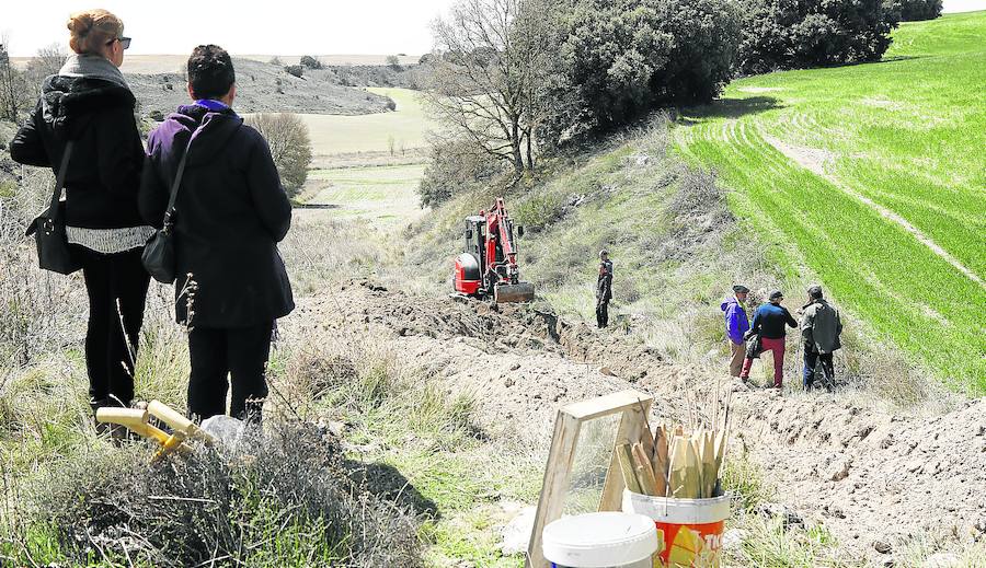 Las palas para la excavación manual y la señalización para las fosas, en primer lugar, mientras trabaja la excavadora. 