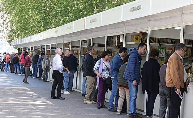 Varios lectores, ayer, ante las casetas de los libreros. 