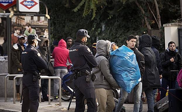 Varias de las personas desalojadas de un edificio junto a sus pertenencias.