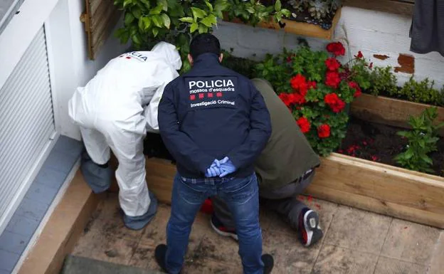 Agentes de la policía científica de los Mossos buscan indicios sobre la víctima en casa del detenido por la desaparición de una mujer en Cornellá (Barcelona).