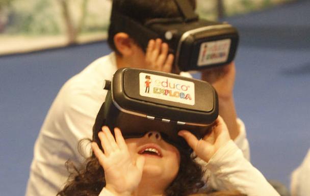 Niños jugando a videojuegos en Gijón con gafas de realidad virtual.