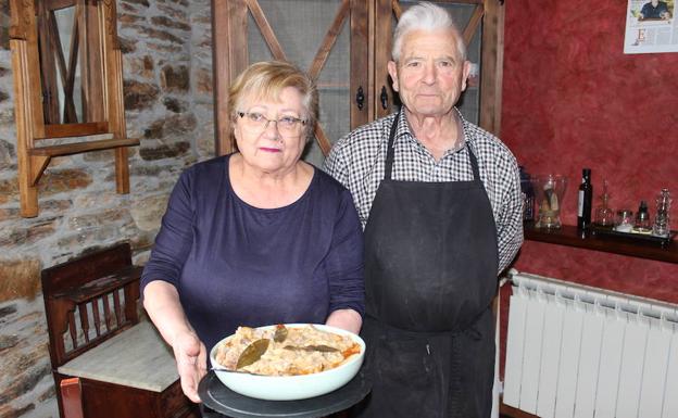 Trini y Ernesto posan con su plato de manitas con alubias. 