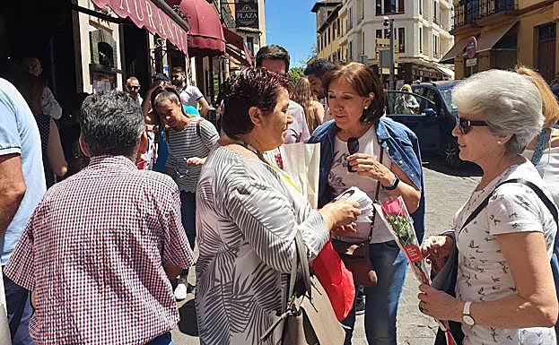 Imagen principal - Arriba, la socialista Clara Luquero reparte rosas rojas en la calle Cronista Lecea; abajo, derecha, Noemí Otero, candidata de Ciudadanos, entrega un folleto a un paseante en la Alameda del Parral; a la izquierda, Cosme Aranguren y Roberto Vigil, de centrados, en el casco histórico. 