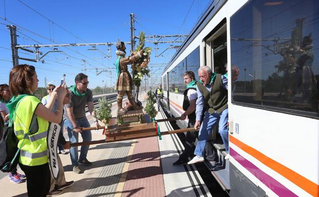 Los participantes en la romería sacan la talla de San Isidro del tren en la estación de Venta de Baños. 