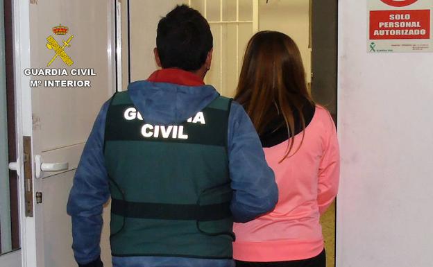 Un agente lleva detenida a la mujer.