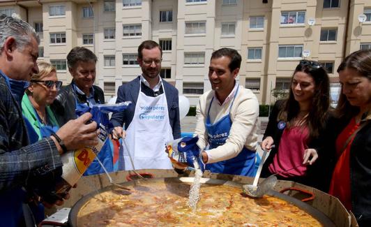 El candidato del PP a la Alcaldía de la ciudad Pablo Pérez echa arroz a la paella pòpular cocinada este domingo en Nueva Segovia. 