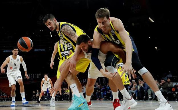 Felipe Reyes lucha por un balón con los jugadores del Fenerbahçe Nikola Kalinic (i) y Jan Vesely. 