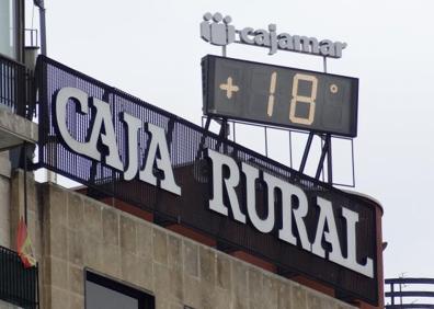 Imagen secundaria 1 - A la derecha, debajo, los operarios reparan el miércoles el reloj digital del edificio de Cajamar (1980), que este jueves a vuelto a dar la hora y la temperatura.