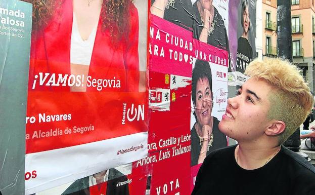 Carlota Moreno observa los carteles electorales en una valla de la ciudad.