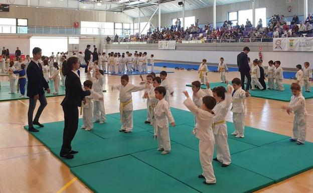 Los aprendices de judocas hacen ejercicios antes de comenzar los combates. 