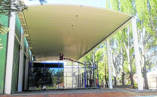 Los operarios dan los últimos retoques a la cubierta de la pista de pádel. 