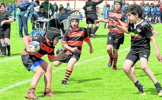 Imagen principal - Un jugador de Les Abelles hace un quiebro ante el de Hortaleza; Pugna por el oval durante el Arquitectura-Estrecho y La defensa del Alcorcón trata de evitar el ensayo de El Salvador.