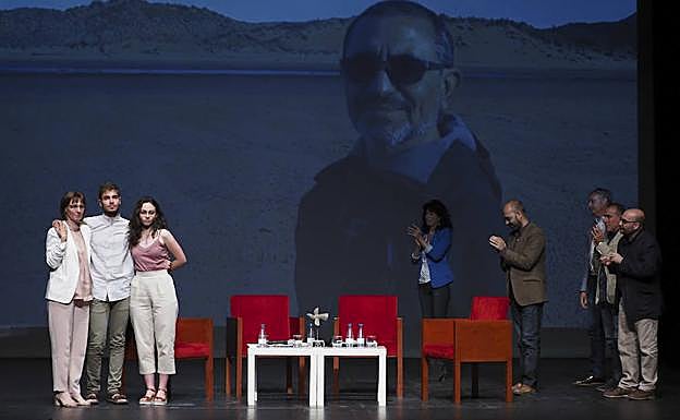 Los hijos y la esposa del escritor, con su imagen de fondo. 