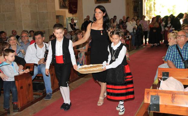 Dos niños acompañados por una de las alcaldesas llevan su ofrenda a la Virgen de la Fuencisla.