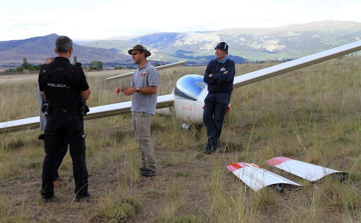 André charla con un policía nacional mientras Arnaud espera junto al planeador. 