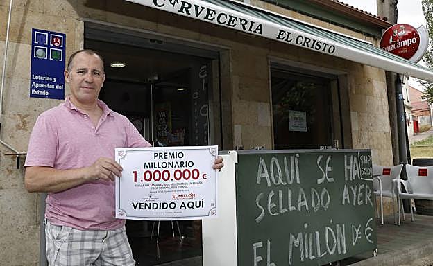 Juan Carlos del Olmo, con el cartel del premio a la puerta de la Cervecería El Cristo. 